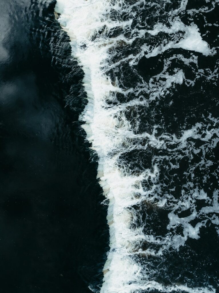 Turbulent white water flowing over dark rocks